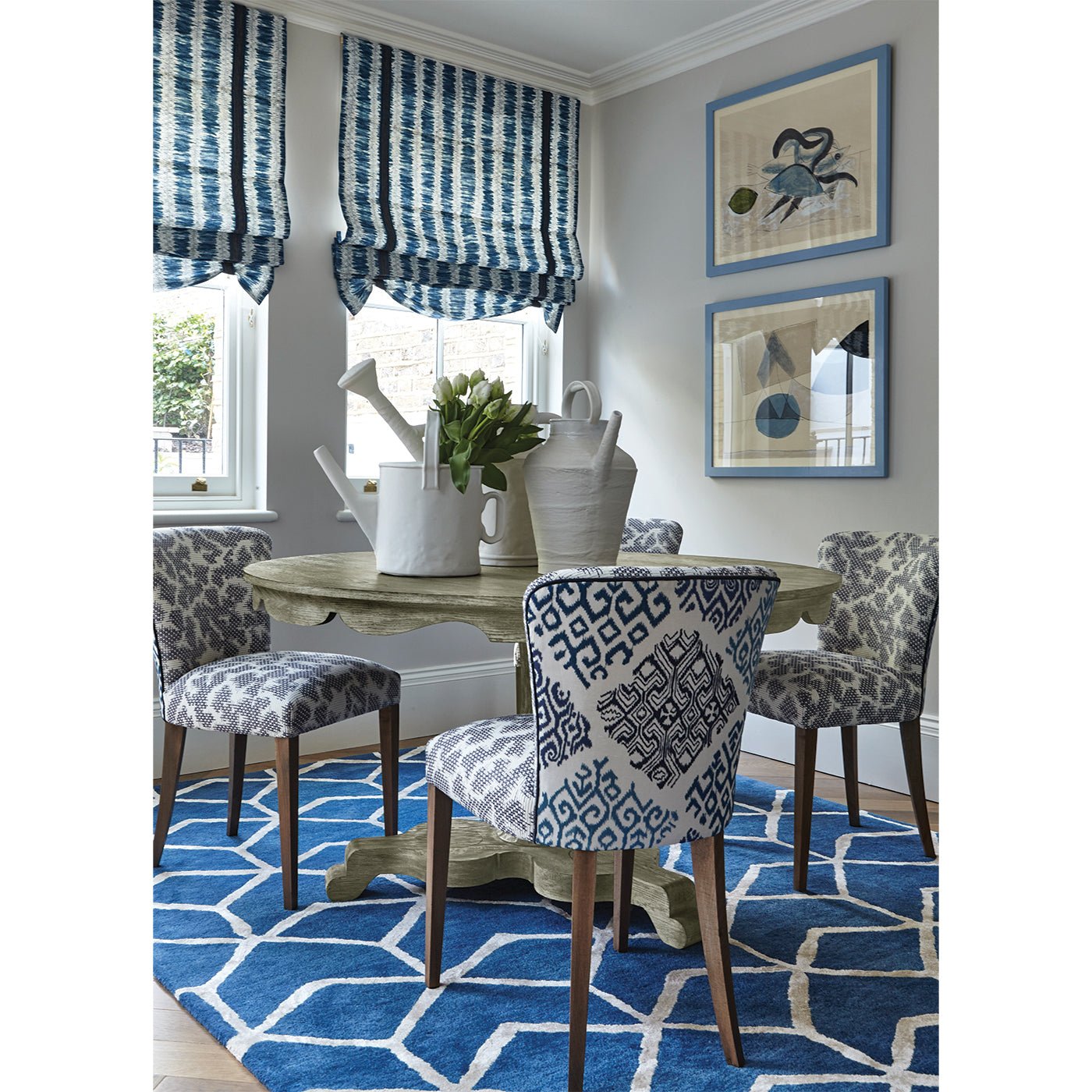 Dining table with patterned chairs, blue rug.