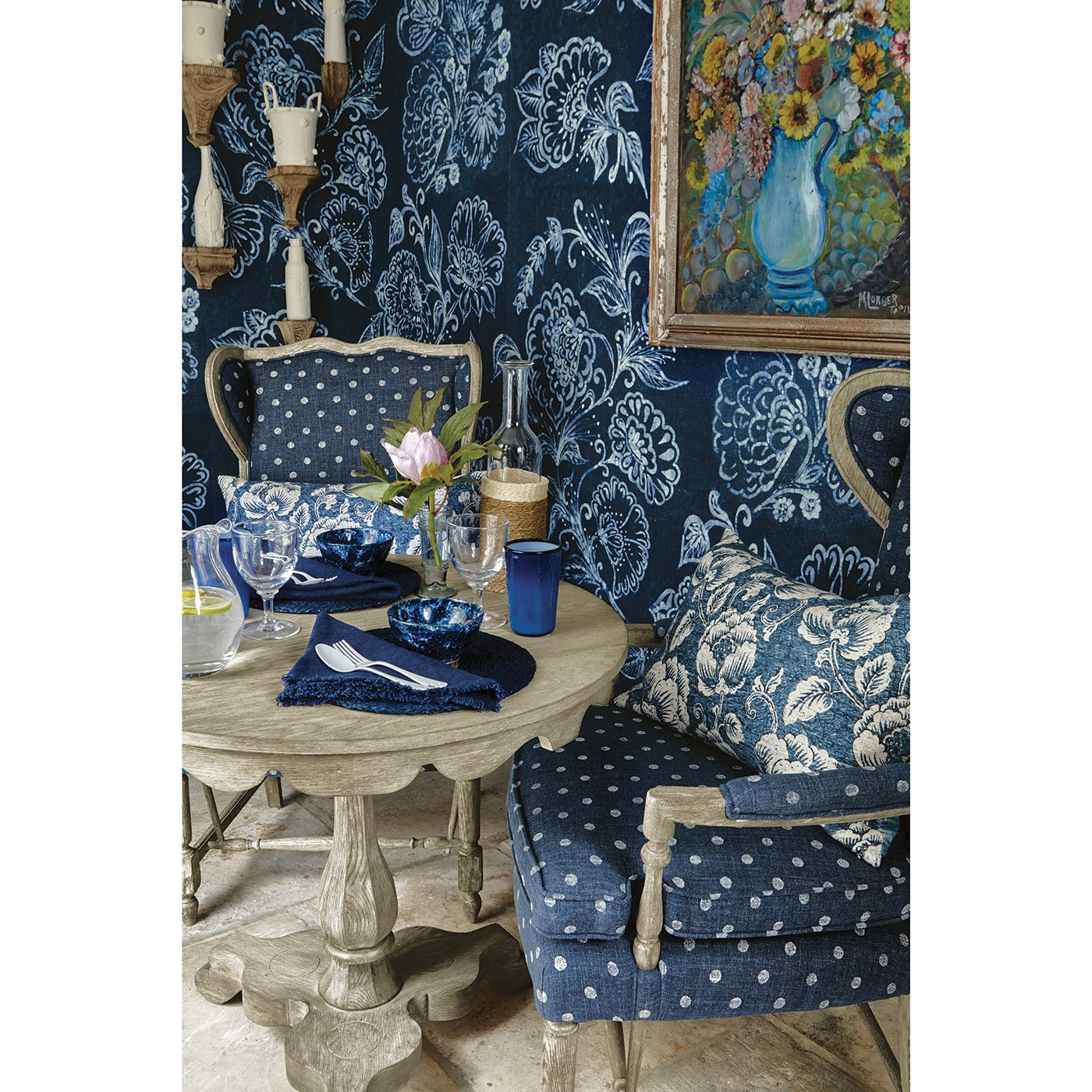 End table styled with blue chairs and floral decor.