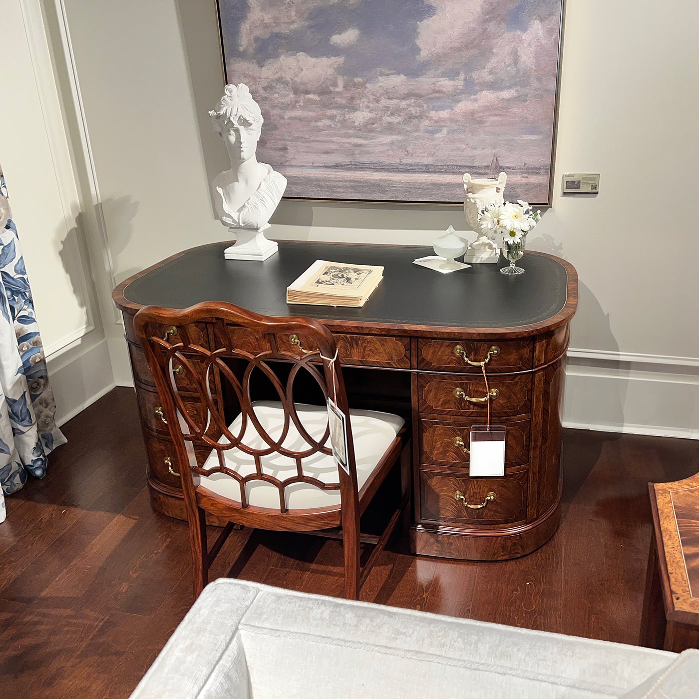 English leather top desk, decorated with chair and art.