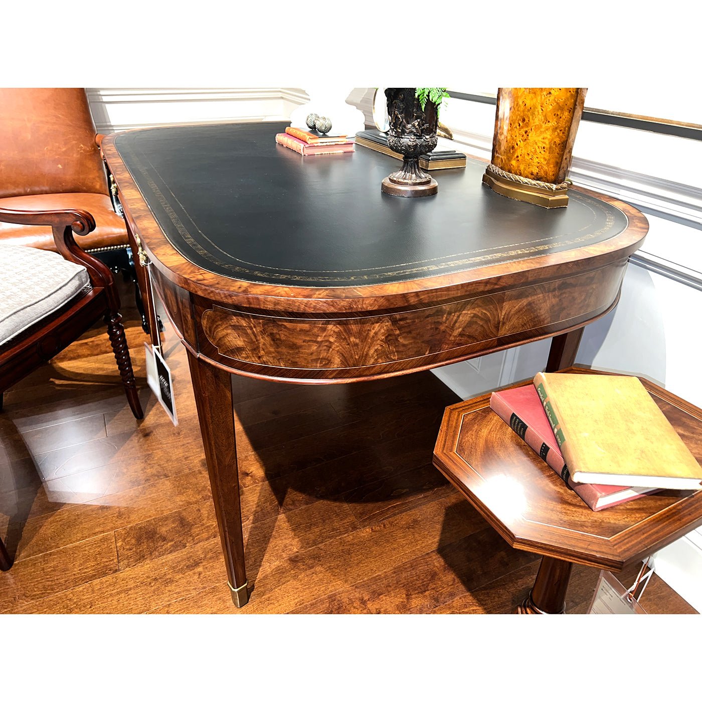 Writing table displayed with nearby books and decorative items.
