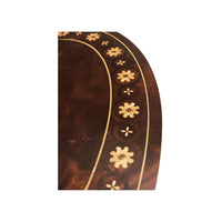 Detailed view of mahogany table surface, floral pattern.
