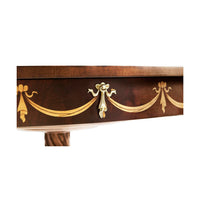 Close-up of mahogany table trim, gold designs.