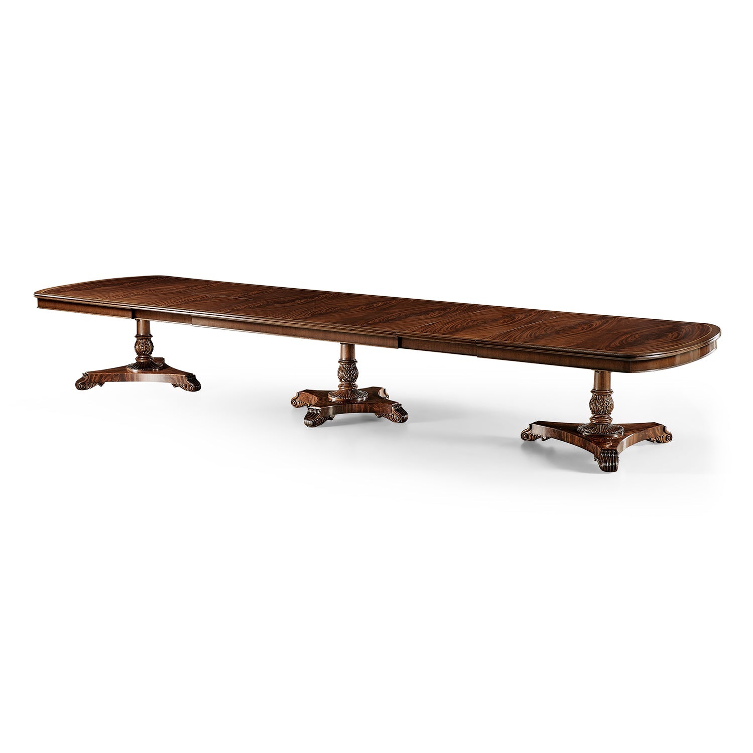 Extended mahogany dining table displaying intricate pedestal design.