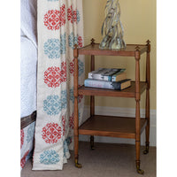 Wooden etagere used as bedside table with books.