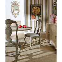 Dining table with chairs, mirrors, and decor setting.
