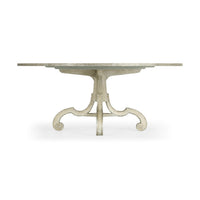 Side view of round oak dining table, intricate base.