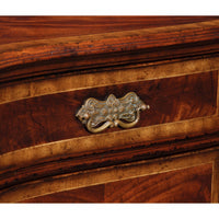 Close-up of ornate brass handle on sideboard drawer.