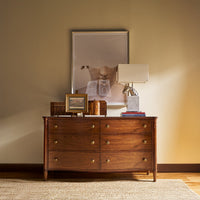 Styled English six drawer dresser with decor on top.