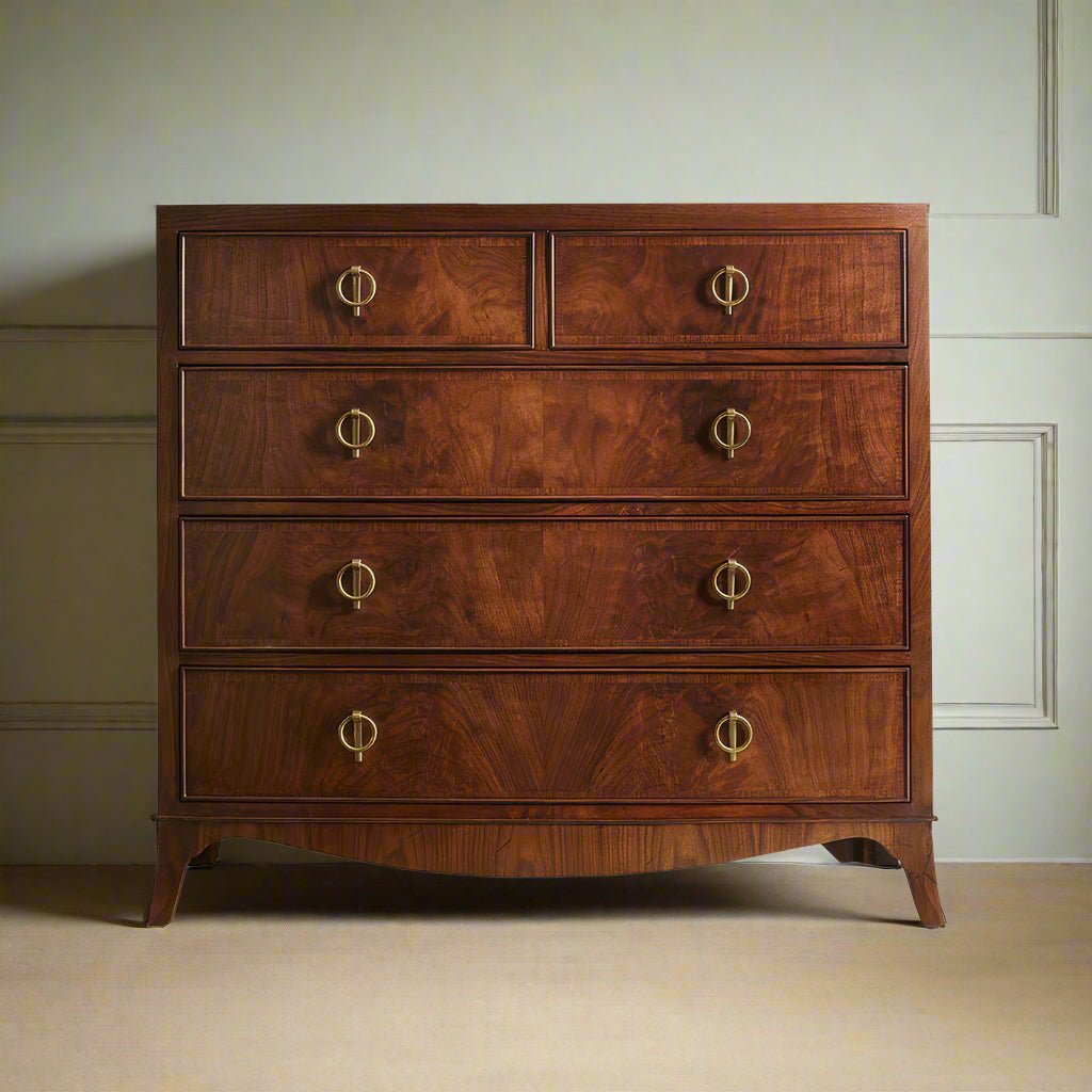 English walnut chest of drawers, against paneled wall.