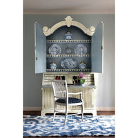 Bookcase open styled with decor, chair in front.