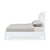 Side profile of white bed showing mattress and pillows.