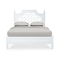 Front view of white queen bed with pillows.