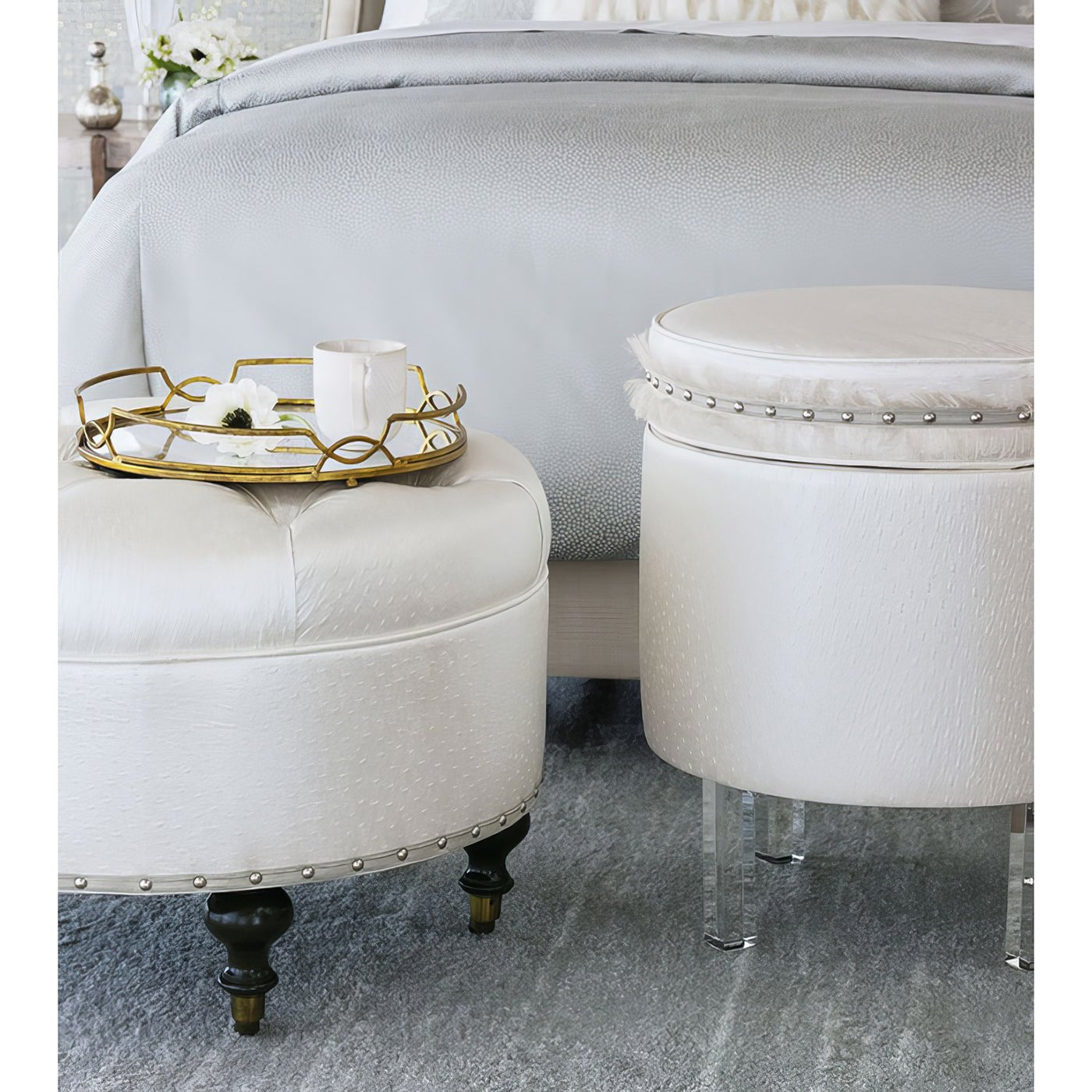 White ottoman beside bed, decorative tray on top.