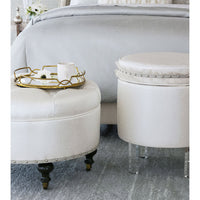 White ottoman beside bed, decorative tray on top.