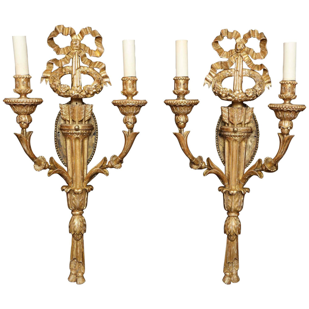 Pair of ornate giltwood sconces with candles.