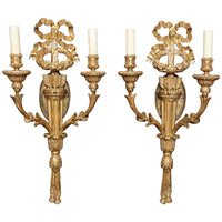 Pair of ornate giltwood sconces with candles.