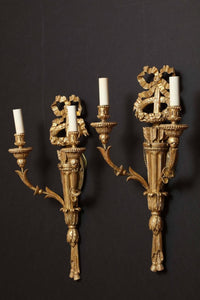 Side view of carved giltwood sconces with candles.