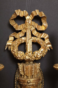 Top view of sconce's ribbon and wreath decoration.