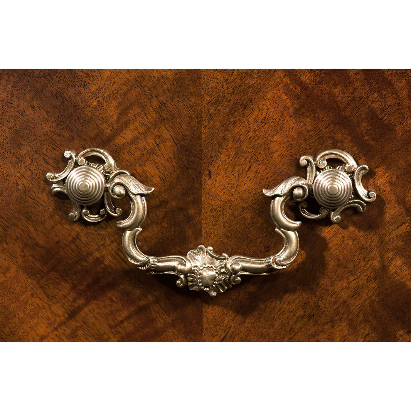 Detailed view of ornate brass dresser handle.