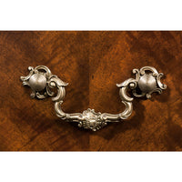 Detailed view of ornate brass dresser handle.