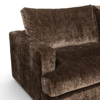 Close-up of brown sectional seat, back cushion and square arm with textured upholstery
