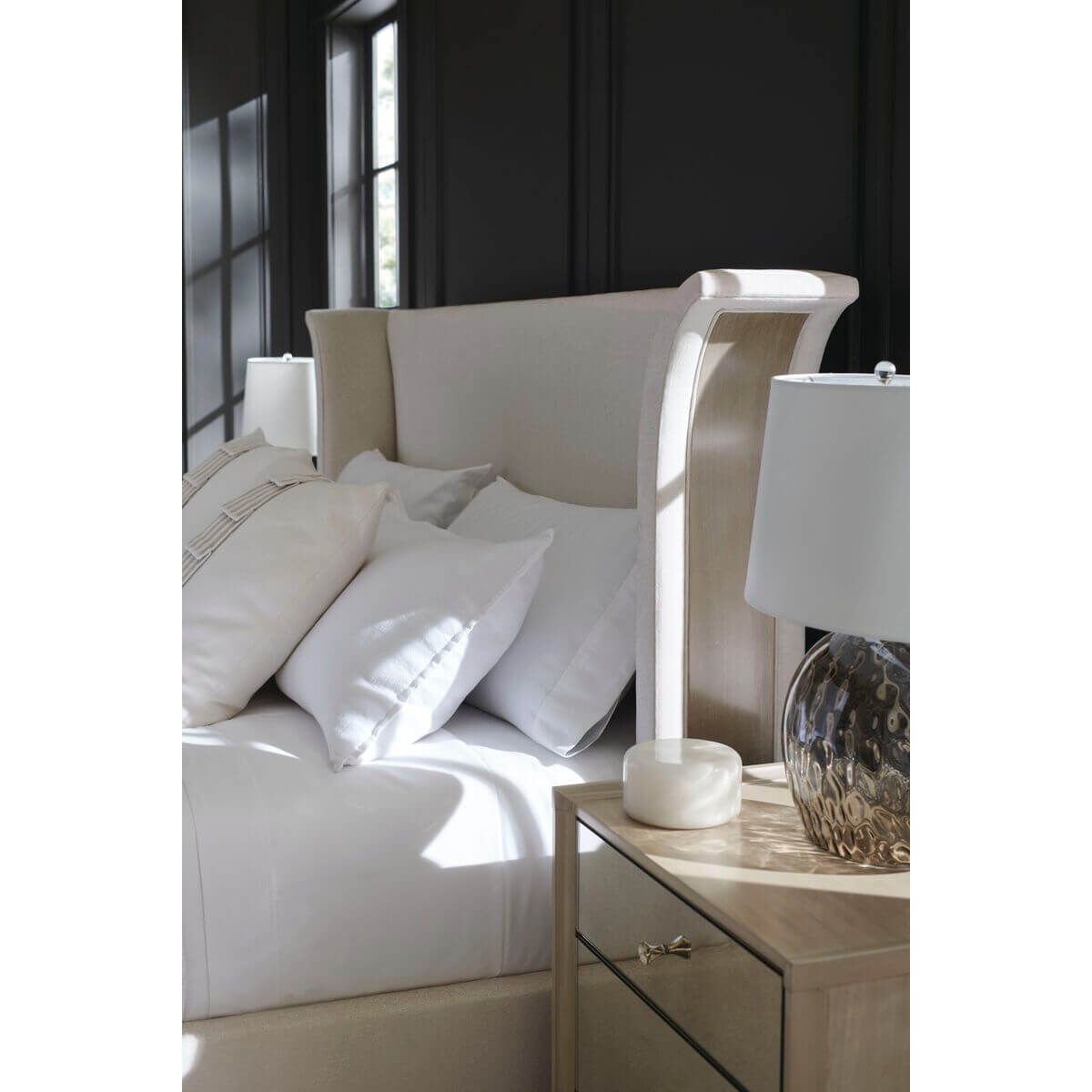 Close-up of upholstered bed headboard with side table.