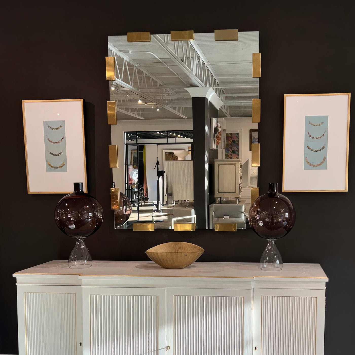Modern mirror on wall, styled above a console table.