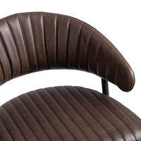 Close-up of the fluted brown leather counter stool’s curved, channel-stitched back and padded seat