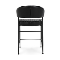 Rear view of the fluted black leather counter stool, showing the smooth curved back and black iron frame