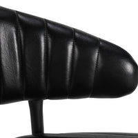 Close-up of the fluted black leather counter stool’s channel-stitched curved back