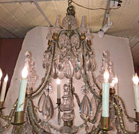 French chandelier lit up, detailed crystal decorations.