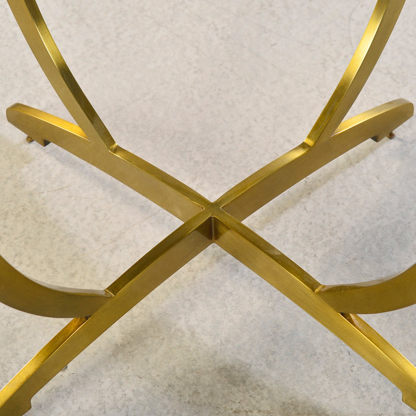 Close-up of gold base cross design on side table.
