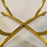 Close-up of gold base cross design on side table.
