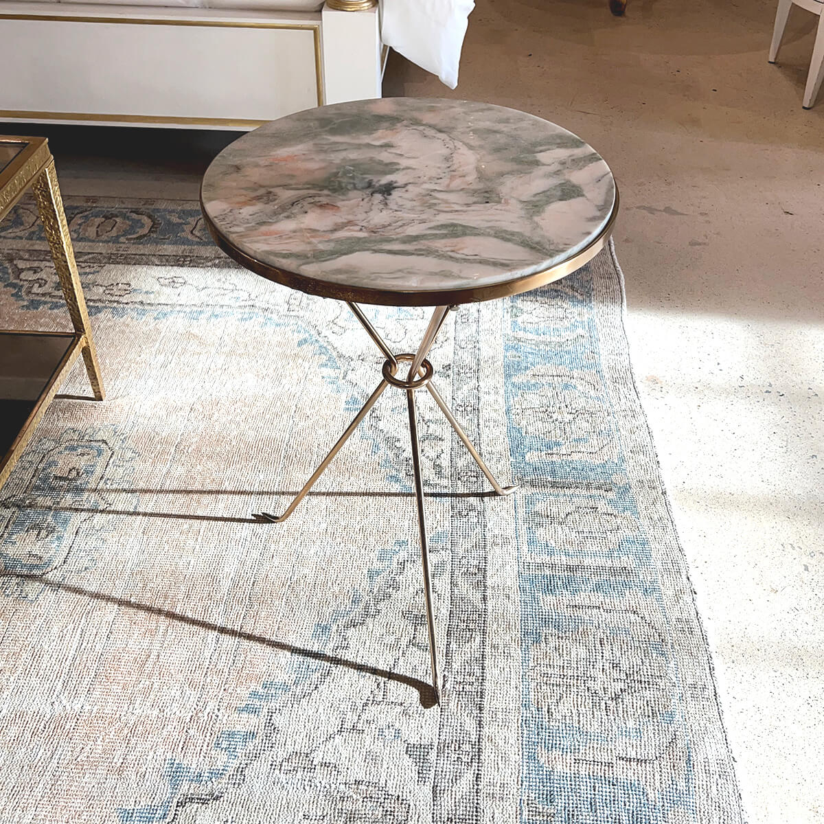 French Art Deco table on patterned rug in room.