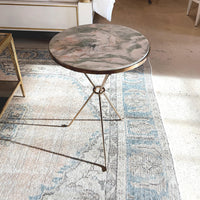French Art Deco table on patterned rug in room.
