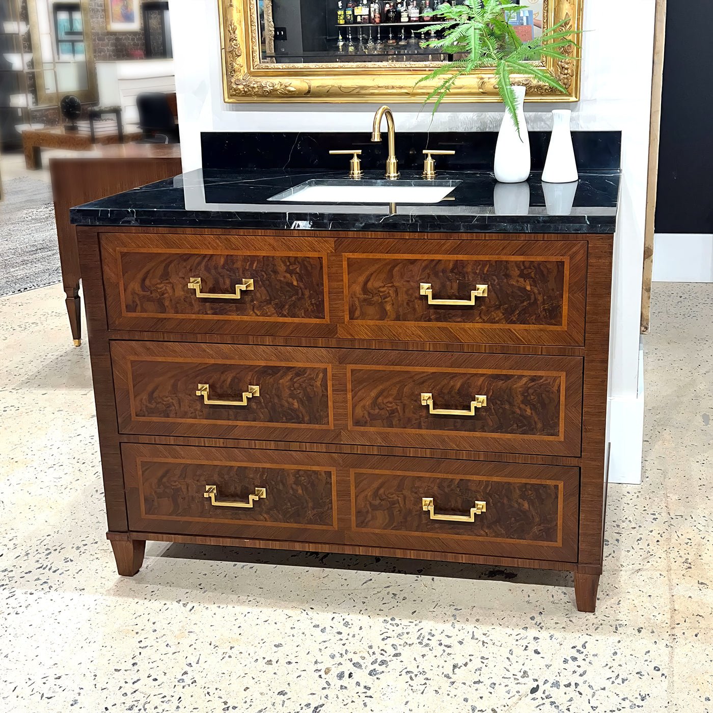 Vanity displayed in showroom with decorative items and mirror.