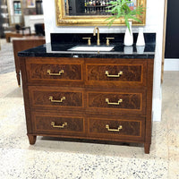 Vanity displayed in showroom with decorative items and mirror.