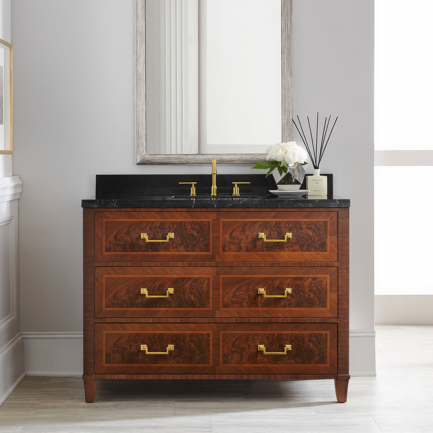 Vanity styled in bathroom setting, mirror and flowers visible.