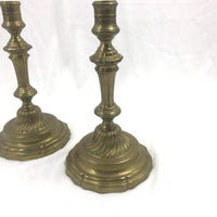 Two French bronze candlesticks, angled view, decorative base visible.