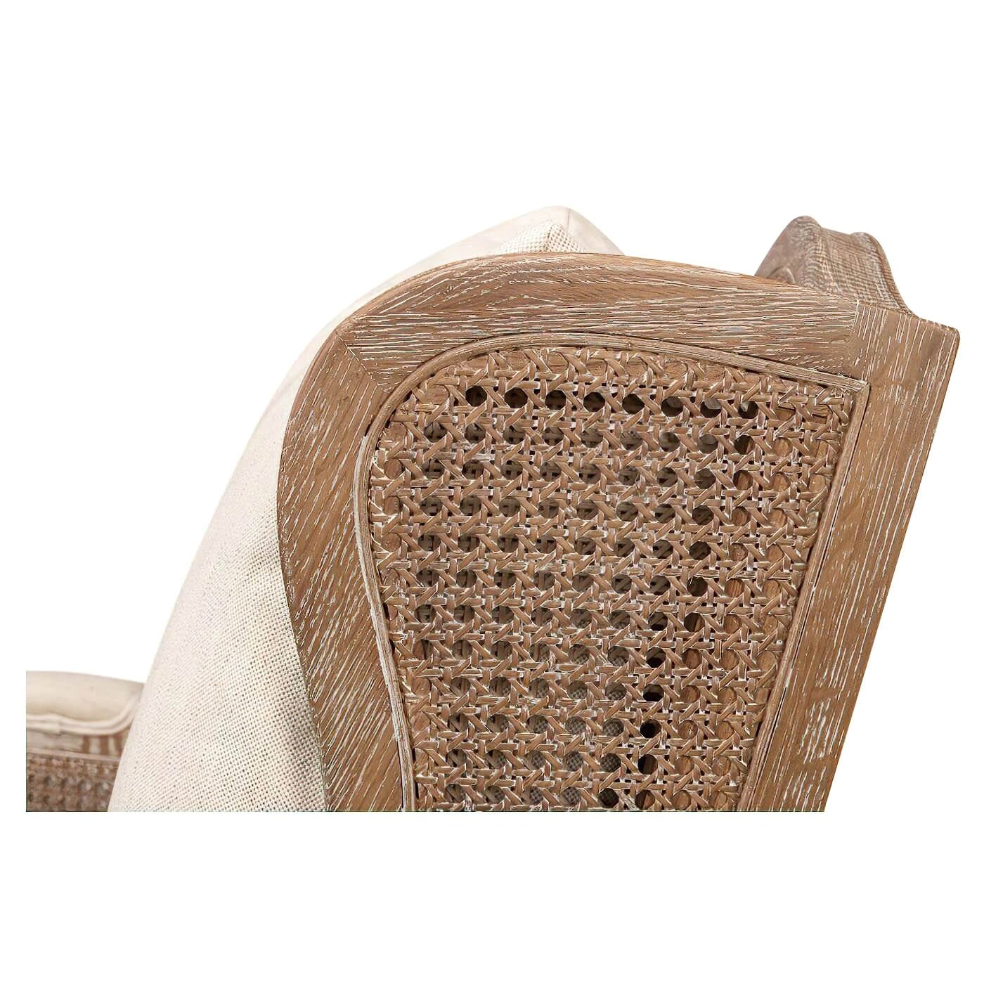 Close-up of woodwork and cane detailing on armchair side.