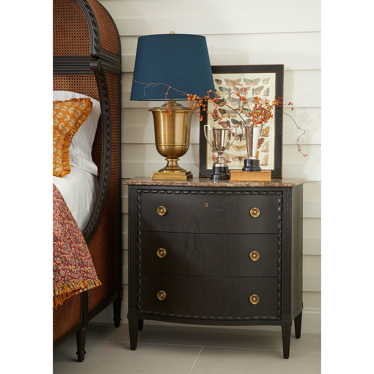 Nightstand beside French caned king bed, decorative setting.