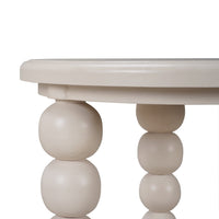 Close-up of beige beaded legs on round side table.
