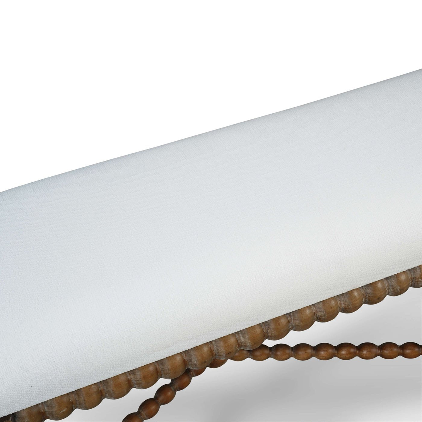 Close-up of wooden bench's white cushioned seating.
