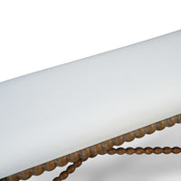 Close-up of wooden bench's white cushioned seating.