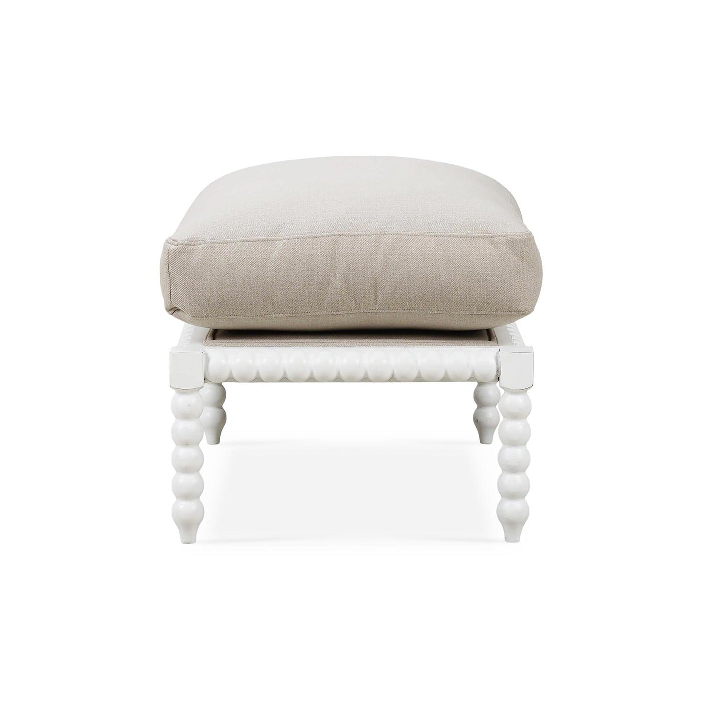 Side perspective of white bobbin ottoman with cushion.