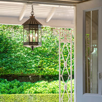 Copper bronze lantern hanging outdoors, garden background view.