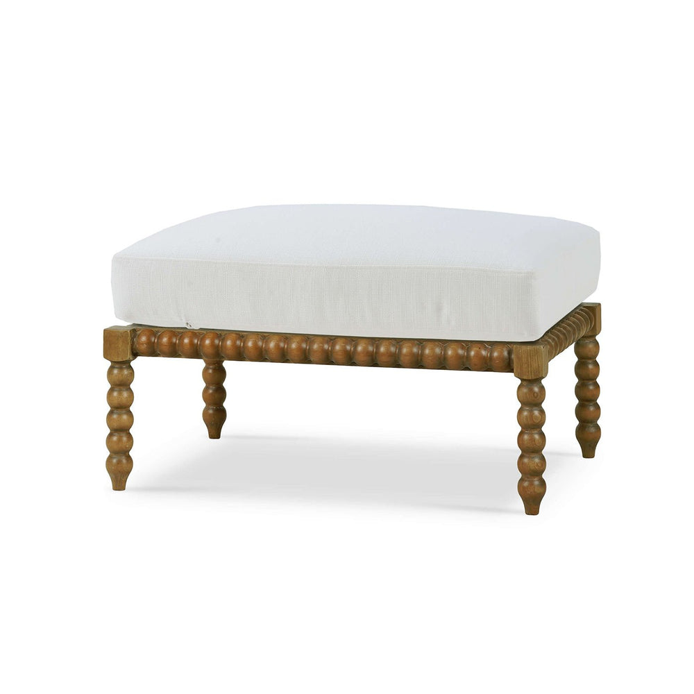 White cushioned ottoman with ornate wooden legs, perspective view.
