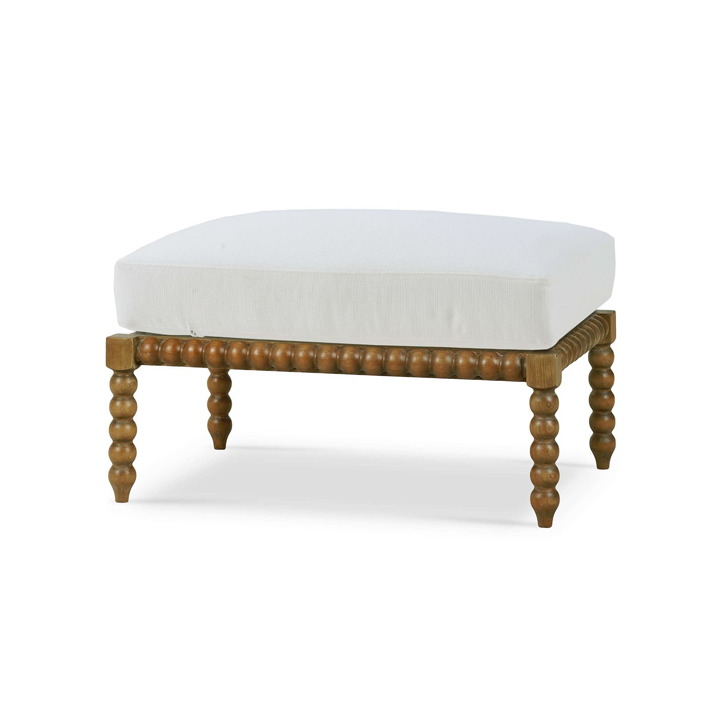 White cushioned ottoman with ornate wooden legs, perspective view.