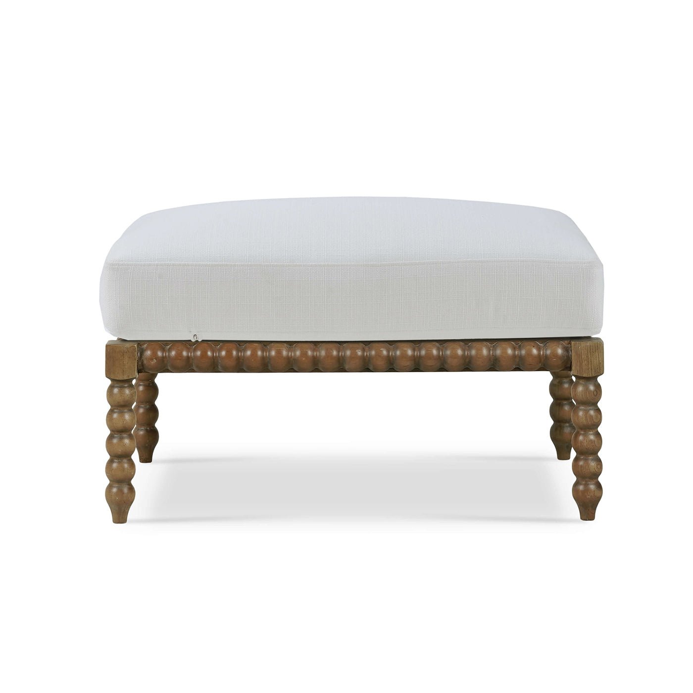 White cushioned ottoman with bobbin legs, front view.