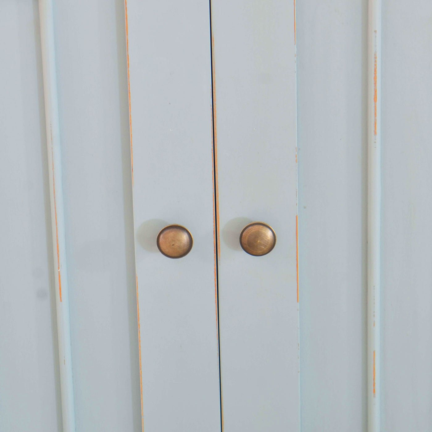 Close-up of sideboard door knobs and panel details.